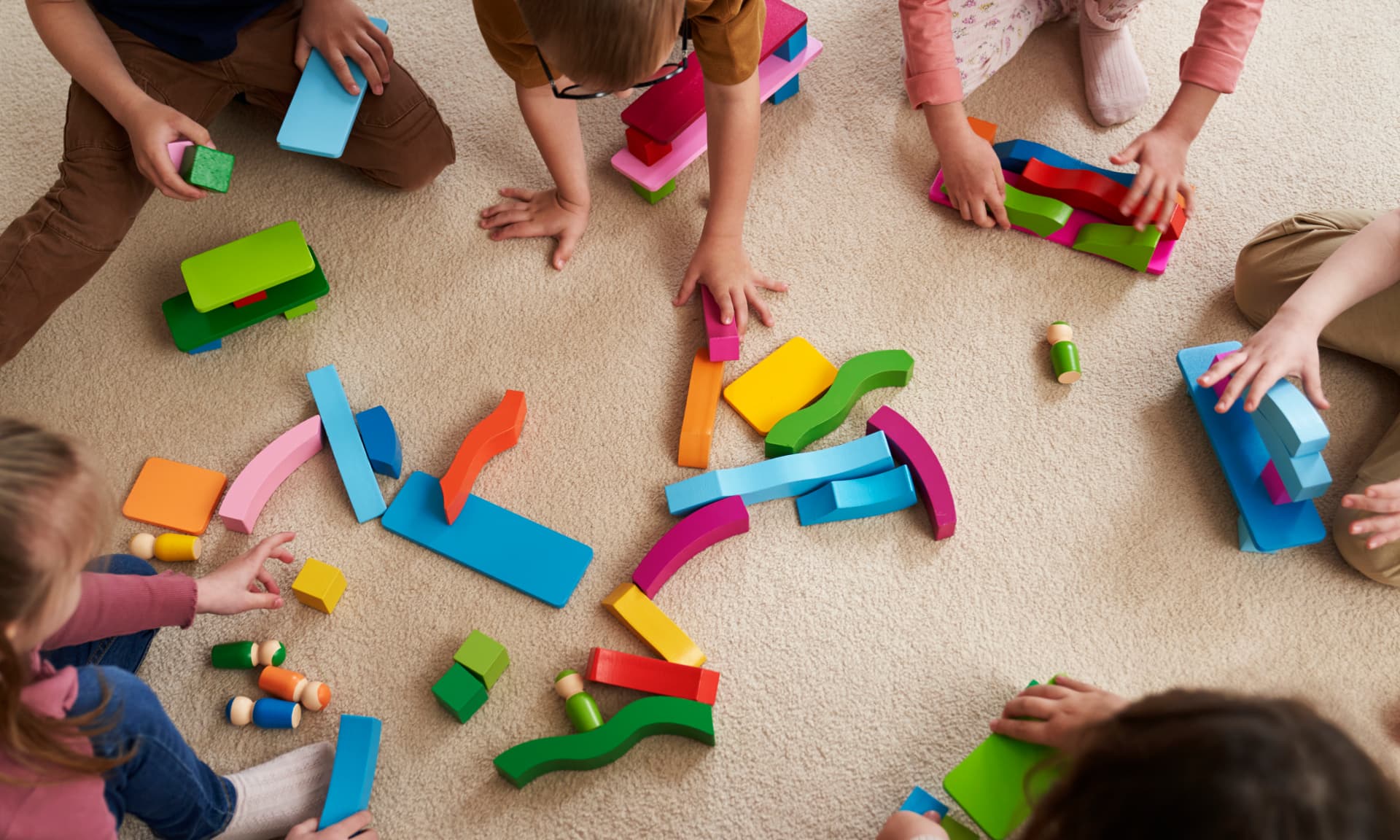 Kids playing with colorful blocks on a carpet