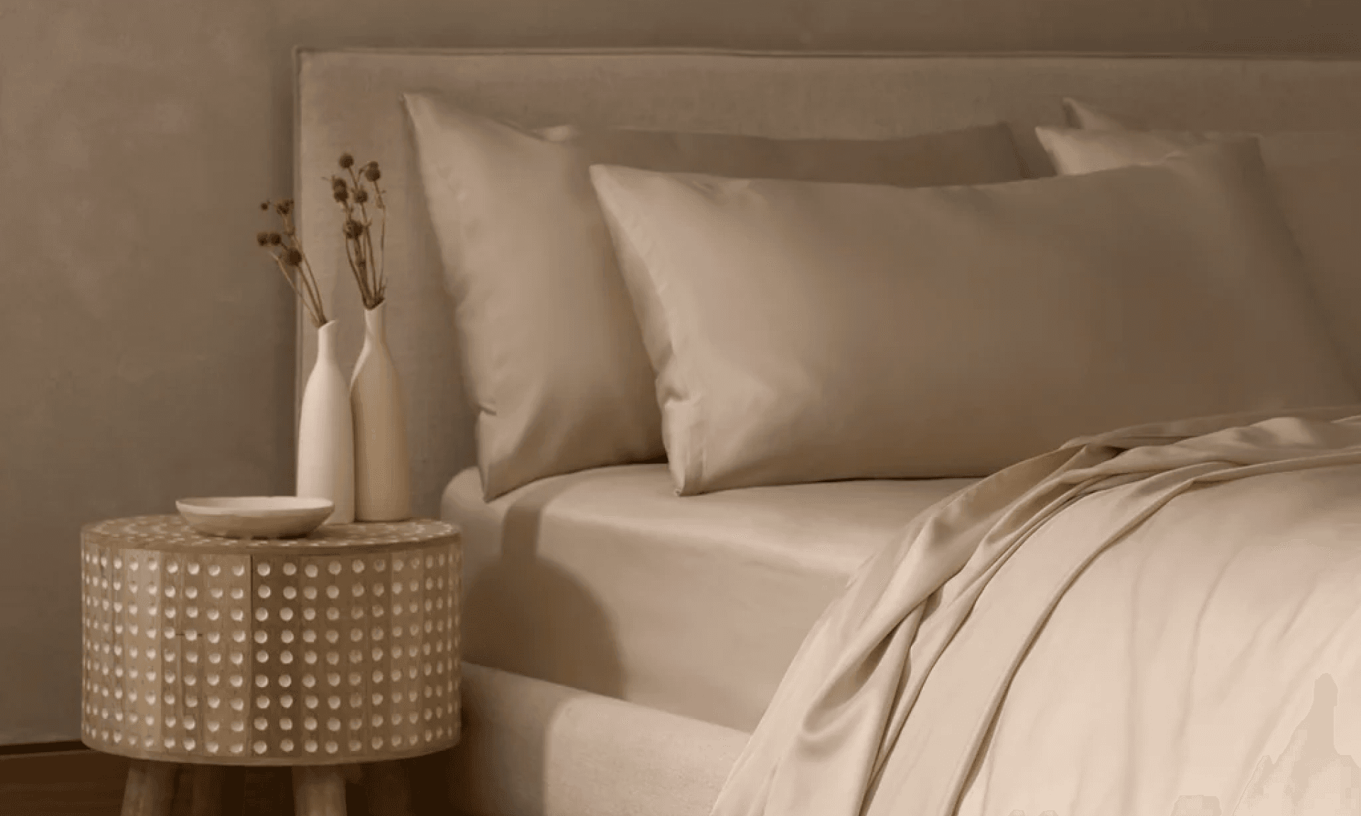 Bedroom featuring beige sheets and a wooden nightstand