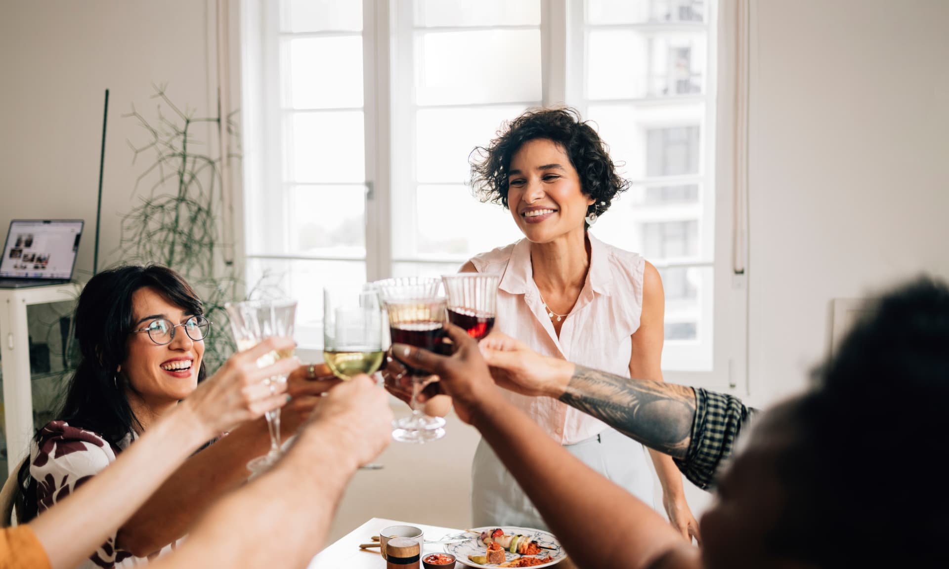 Woman hosting dinner at home with friends
